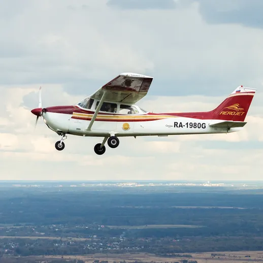 Летящий легкий самолет над живописным пейзажем в ясный день