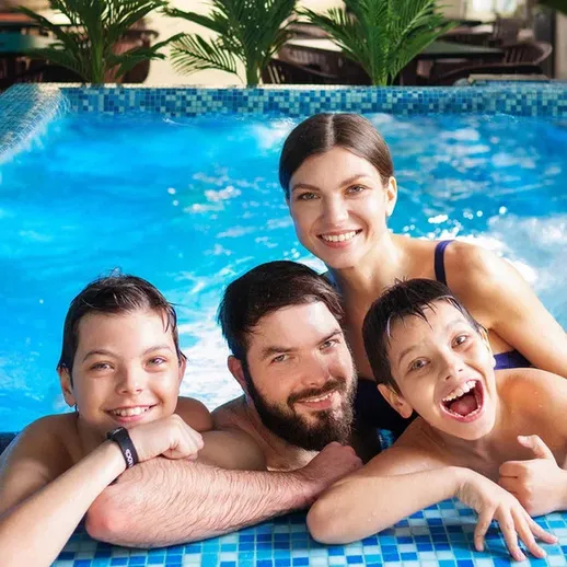 Семья отдыхает у бассейна в солнечный день в отеле