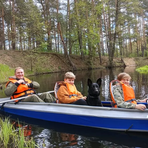 Путешествие на лодке по живописной реке с детьми и собакой в лесу весной