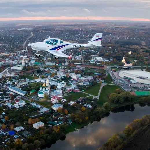 Самолет над городом с реками и зелеными парками на закате с красивым горизонтом