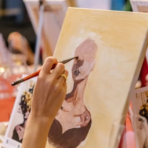 Участник рисует картину на мастер-классе по живописи в студии в вечернее время