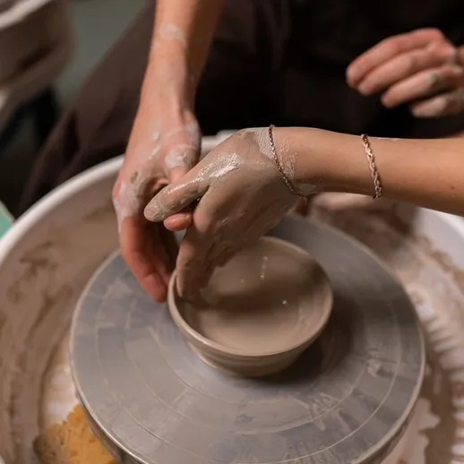 Работа с глиной на гончарном круге в мастерской в вечернее время