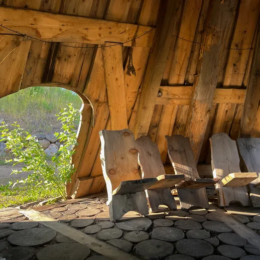Уютное деревянное пространство с креслами в природном окружении и солнечным светом