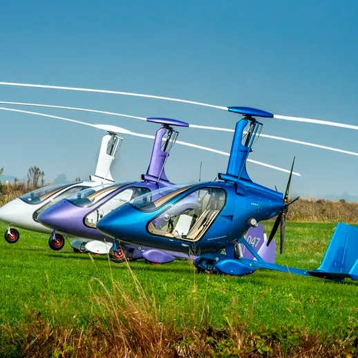 Три вертолета на зелёном поле под ясным небом в солнечный день