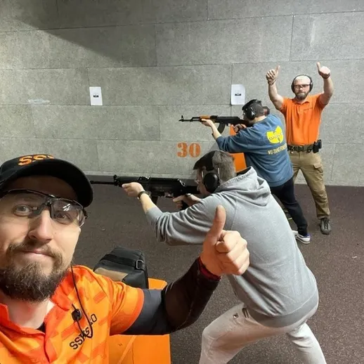 Тренировка стрельбы в тире: группа людей упражняется с оружием в закрытом помещении