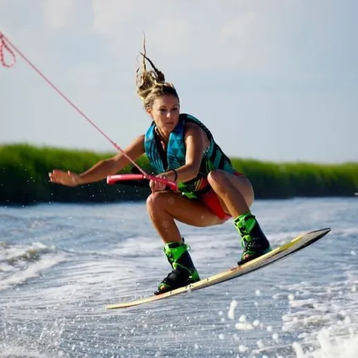 Девушка катается на вейкборде на воде в солнечный день