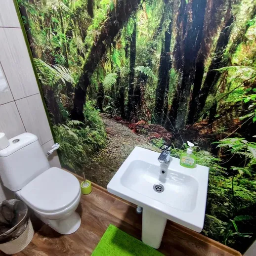 Уютный туалет с экологическим дизайном и лесным пейзажем на стене в современном интерьере