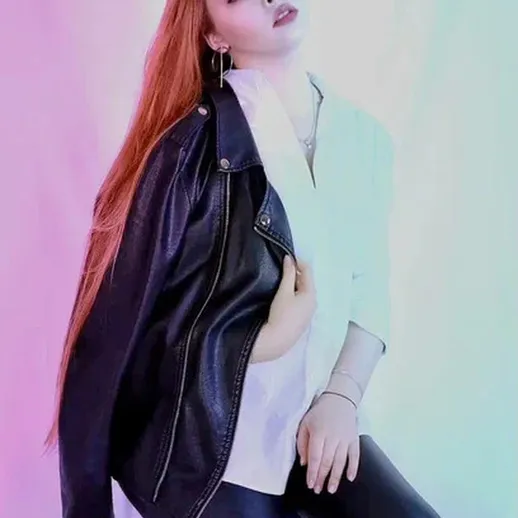 Молодая женщина позирует в стильной кожаной куртке на фоне светлых пастельных тонов, создавая эффектный модный образ