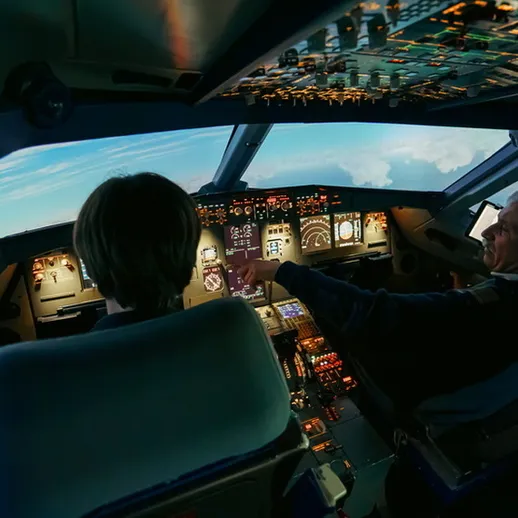 Пилоты проводят тренировочный полёт в симуляторе на высоте с видом на облака и небо