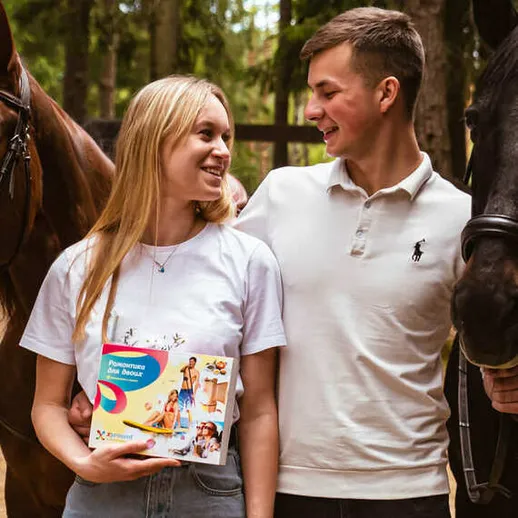 Молодая пара на конной ферме наслаждается общением с лошадьми во время активного отдыха на природе Молодая пара на конной ферме наслаждается общением с лошадьми во время активного отдыха на природе