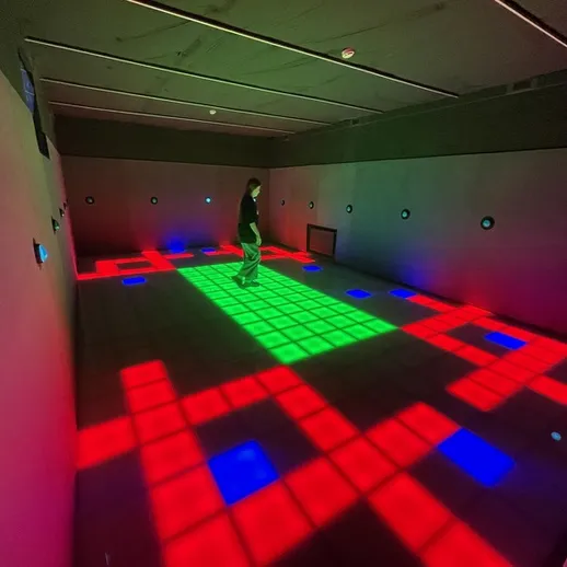 Яркое интерактивное пространство с цветными световыми проекциями в современном выставочном зале