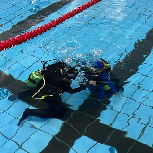 Подводное погружение дайверов в бассейне: тренировка навыков подводного плавания в вечернее время