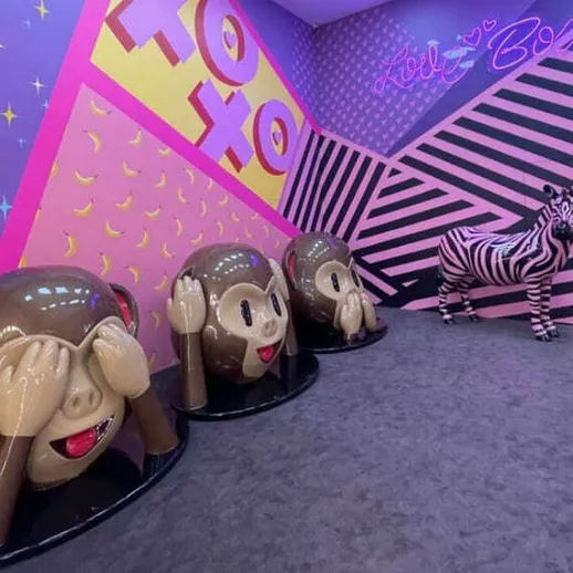 Интересное оформление комнаты с статуями обезьян и зеброй в ярких цветах, размещенное в развлекательном центре