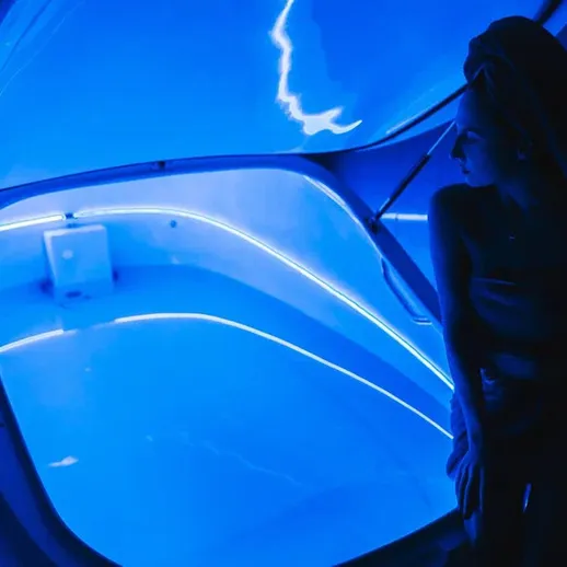 Синяя комната с соленой водой и женщиной, ожидающей сеанса расслабления и восстановления