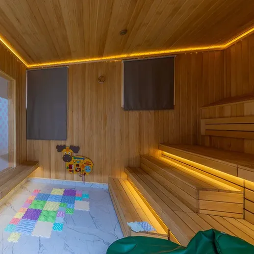 Внутреннее пространство сауны с деревянными стенами и освещением в вечернее время