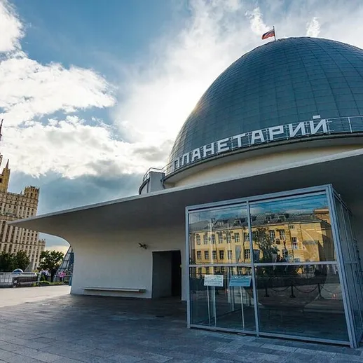 Планетарий в Москве на фоне облачного неба и архитектуры в золотых тонах в ясный вечер