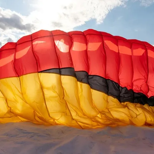 Параплан с флагом Германии над живописным ландшафтом в ясный день