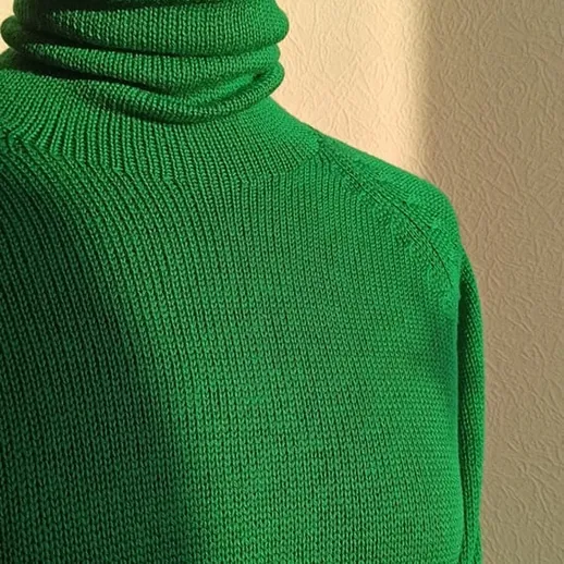 Зеленый свитер на манекене освещен солнечным светом в комнате