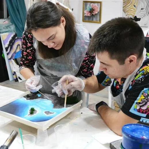 Молодые люди создают акриловую картину на мастер-классе в художественной студии