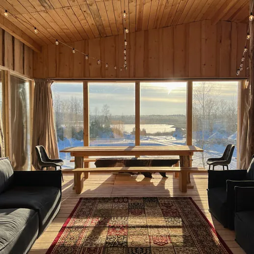 Уютная деревянная беседка у озера с панорамными окнами и зимним пейзажем на фоне