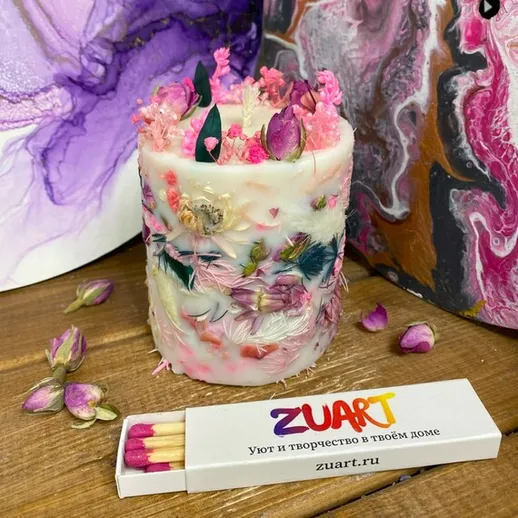 Ароматическая свеча с цветами и декором на деревянном столе в домашней обстановке