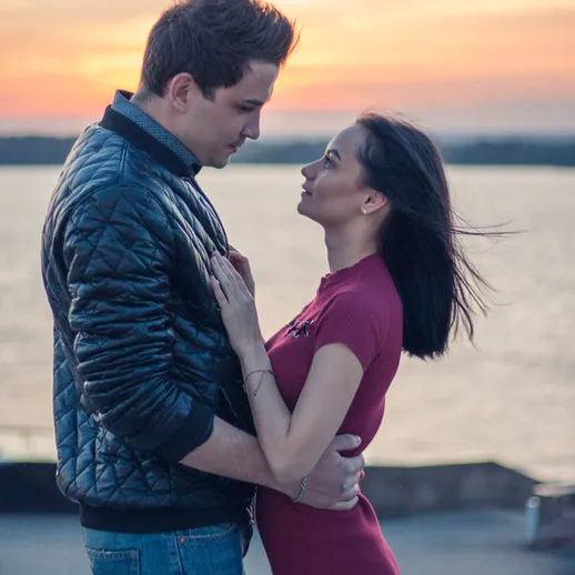 Романтический момент на закате у воды с парой, наслаждающейся близостью друг друга