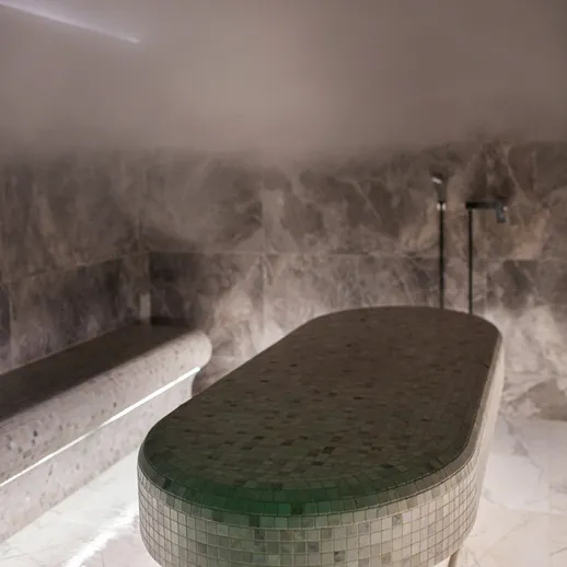 Парная с мраморными стенами и столом для процедур в спа-салоне
