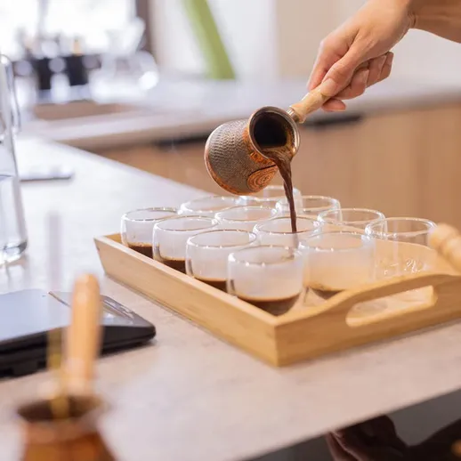 Приготовление кофе в кафе с использованием медной джезвы и прозрачных стаканов