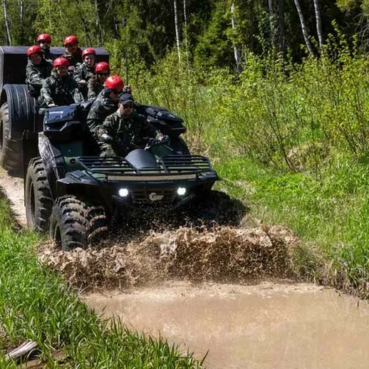 Вездеход с военными проходит через грязной участок дороги в лесу весной