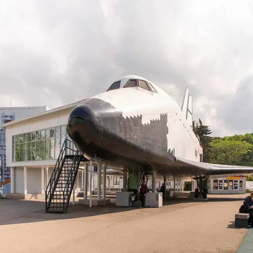 Космический шаттл и музейный центр в парке, посещаемый туристами в солнечный день