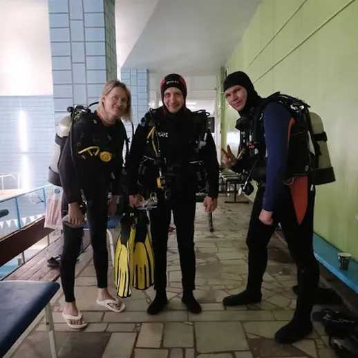 Группа дайверов готовится к погружению в бассейн в спортивном комплексе в зимний день