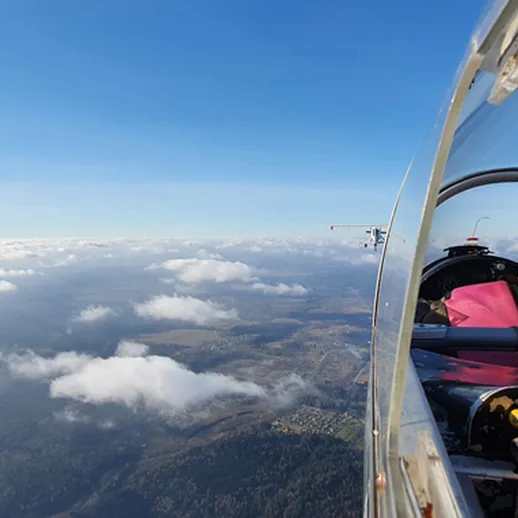 Полет на маленьком самолете над облаками в ясный день