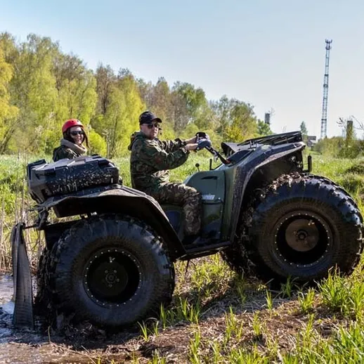 На квадроцикле проезжают через болотистую местность весной, исследуя окрестности леса