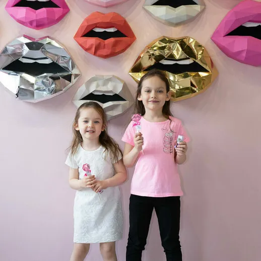 Девочки с мороженым на фоне ярких губ в кафе, наполненном радостью и смехом