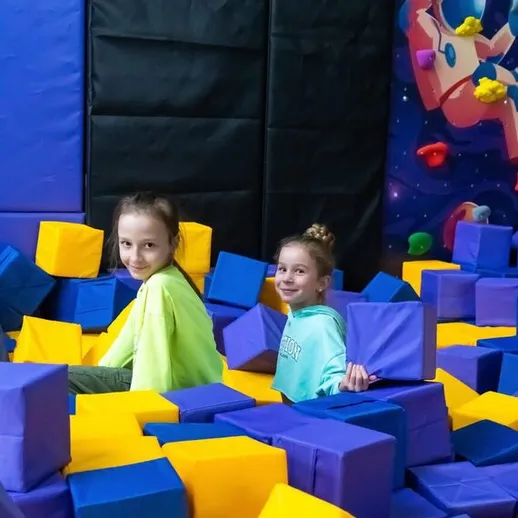 Две девочки играют в прыжках с блоками в ярком батутном центре в Москве