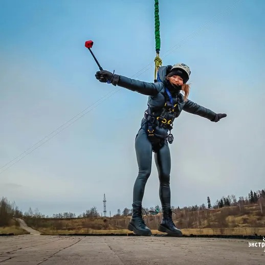 Экстремальные виды спорта: девушкой выступающая в парашюте на фоне пейзажа под открытым небом