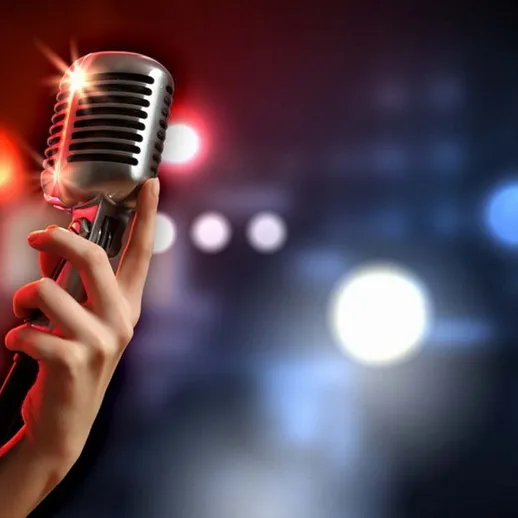 Микрофон на сцене с эффектом яркого света в тёмной обстановке во время выступления музыканта