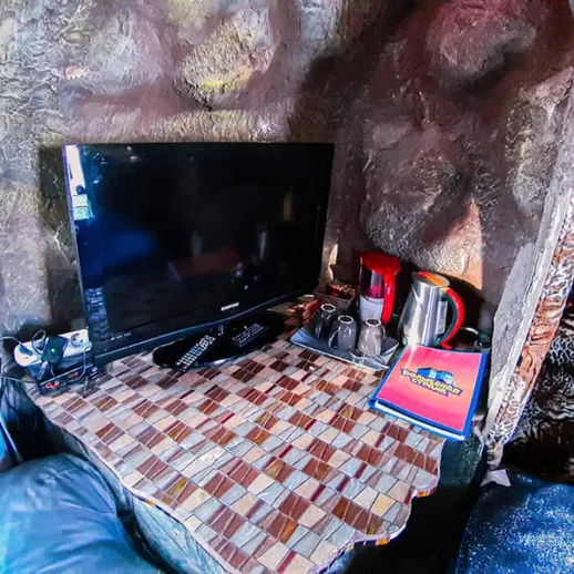 Уютный уголок с телевизором и кухонными принадлежностями в нестандартном интерьере