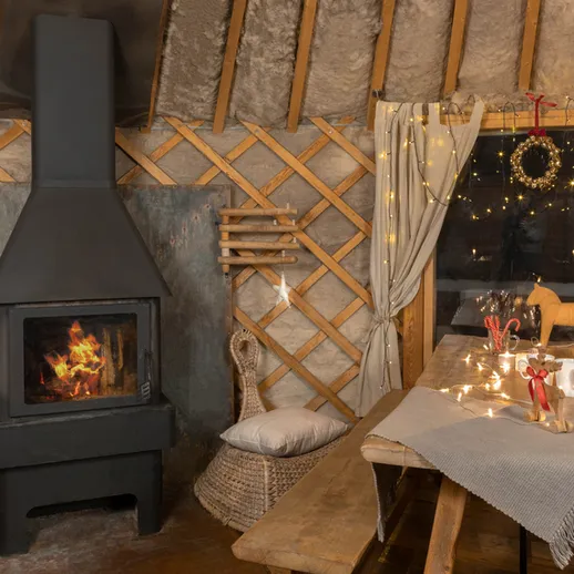 Уютный интерьер юрты с камином и праздничным декором в зимний вечер