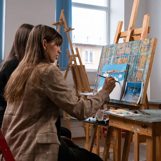 Художницы за работой во время занятия по живописи в светлом студийном помещении