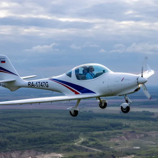 Летательный аппарат над живописным ландшафтом в облачное время на фоне зелёных полей