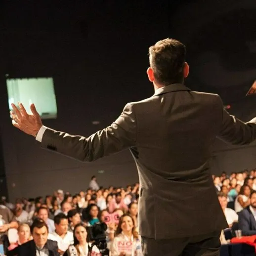 Выступление ораторов перед большой аудиторией на мероприятии в современном конференц-зале в дневное время