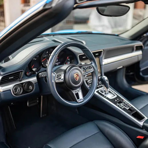 Внутри спорткара на месте водителя в солнечную погоду