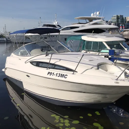 Яхта на причале в солнечный день недалеко от речного порта с лодками вокруг