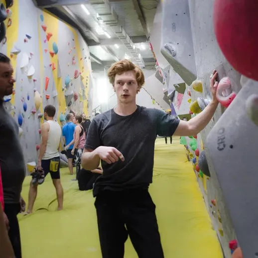 Молодые альпинисты обсуждают тактику перед восхождением в спортзале в Москве