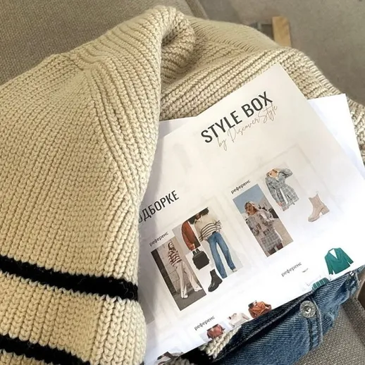 Стильная одежда в коробке на диване с записями о модных комбинациях