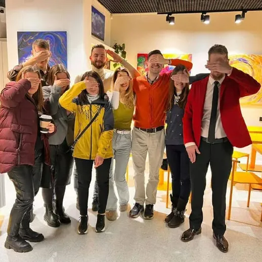 Группа людей в яркой обстановке на мероприятии, проходящем в уютном кафе в центре города