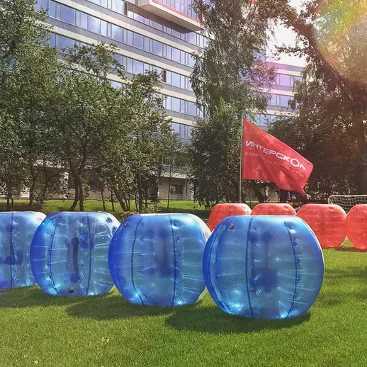 Событие на травяном поле с яркими шарами для игр, расположенное в городском парке в солнечный день