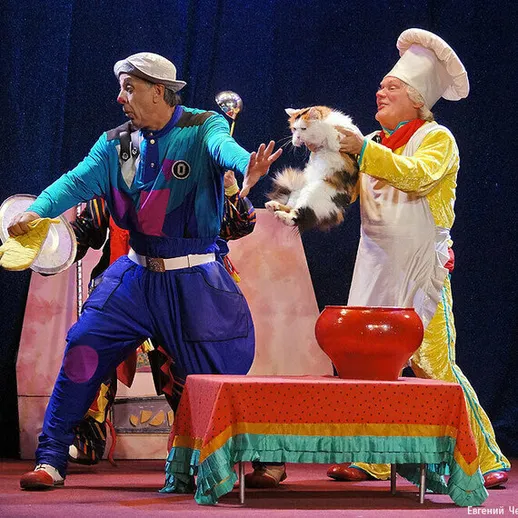 Комедийное представление с актерами и котом на сцене театра в светлом костюме