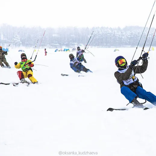 Лыжные гонки на снегу с парашютами на замерзшем озере в зимний день